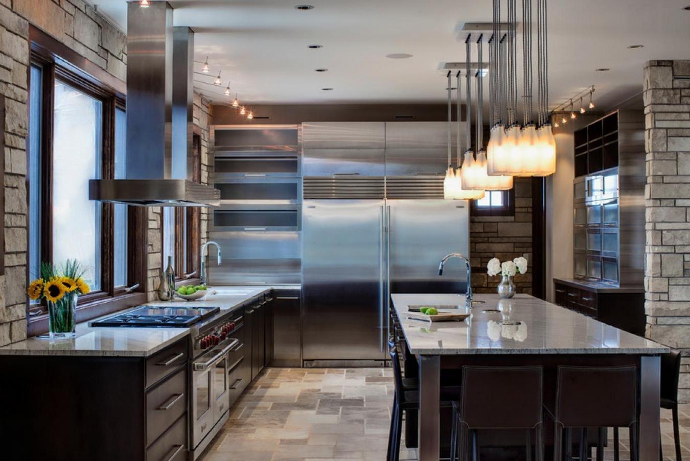 Modern-kitchen-interior-with-a-high-tech-cuisine-and-big-fridge-along-with-fine-dining-space-with-beautiful-hanging-lamps-decor